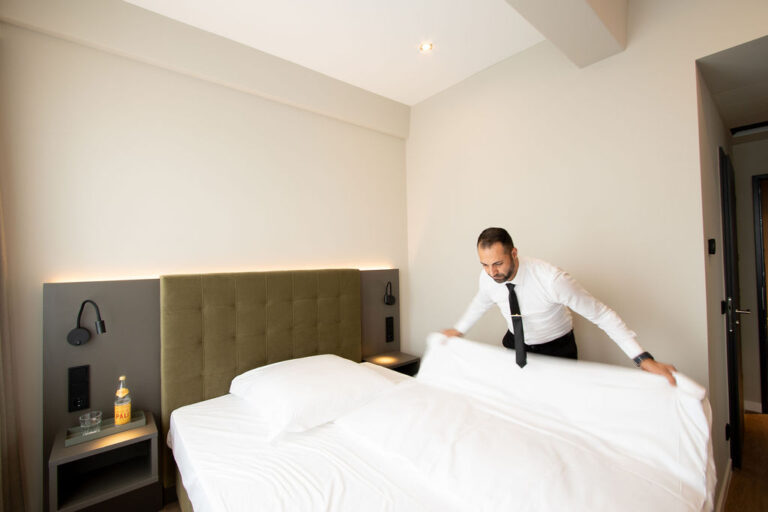 Man making bed in East Five Hotel